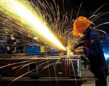 Modern steel fabrication factory with worker and industrial equipment